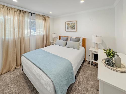 a white bedroom with a bed and a window at F-20 Paradise Pier in Anaheim