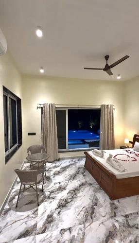 a bedroom with a bed and a large window at Aarambh Villa in Sātirje