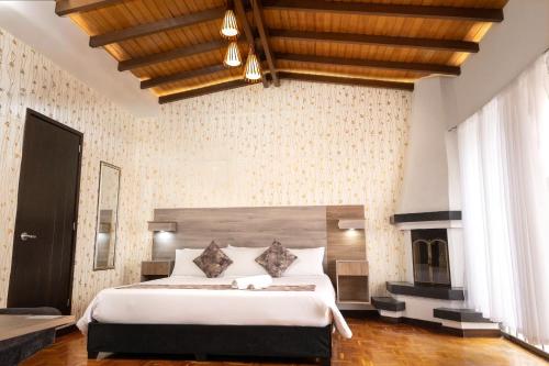 a bedroom with a large bed and a fireplace at Hotel Versalles Boutique in Pasto