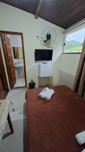 a bedroom with a bed with a sink and a mirror at Pousada Iasbeck in Santa Rita de Jacutinga