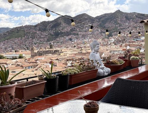 a view of a city with a statue and potted plants at Eco Home View - Guest House in Cusco