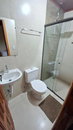 a bathroom with a toilet and a shower and a sink at Pousada Iasbeck in Santa Rita de Jacutinga