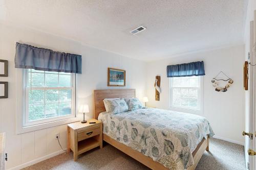 a bedroom with a bed and two windows at AV054 Blue Dolphin in Avon