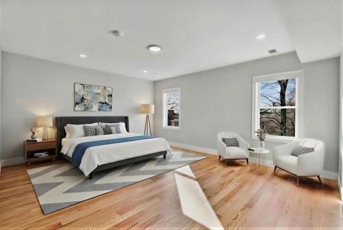 a white bedroom with a bed and a chair at 4BR5BA Luxury World Cup hub in North Bergen