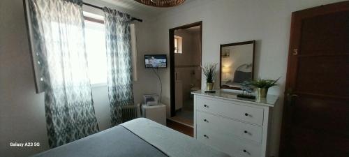 a bedroom with a bed and a dresser and a mirror at Casa Mestre Guesthouse in Vila do Bispo