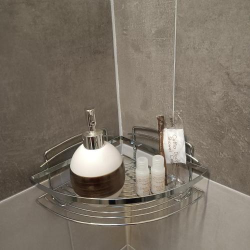 a soap dispenser on a glass shelf in a bathroom at L' Abbraccio in Caiolo