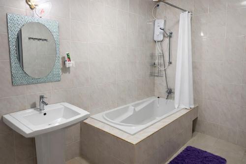 ein Badezimmer mit Waschbecken, Badewanne und Spiegel in der Unterkunft Harmony Home in Willemstad