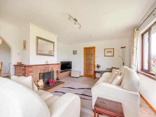 a living room with white furniture and a fireplace at Glenview in Appin