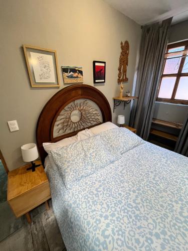 a bedroom with a large bed with a wooden headboard at El Balcón de SúperAnfitrión Coyoacan in Mexico City