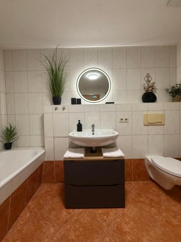 a bathroom with a sink and a tub and a mirror at MarktQuartier Bad Schandau in Bad Schandau