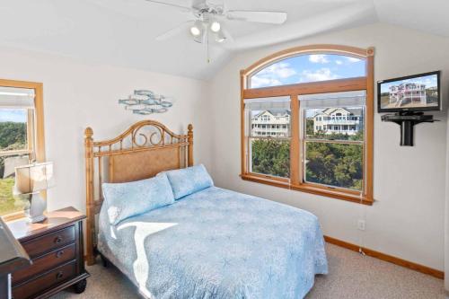 a bedroom with a bed with a blue comforter and two windows at AV13 Time Away in Avon