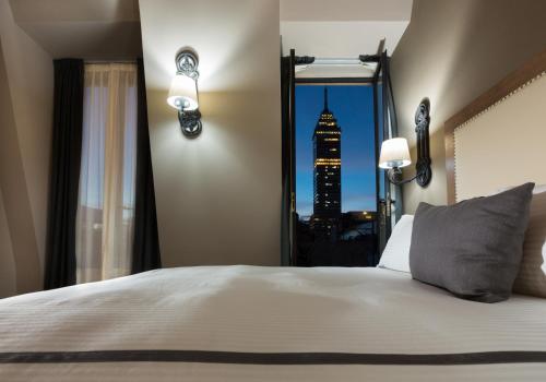 a bedroom with a bed with a view of a city at Historico Central Hotel in Mexico City