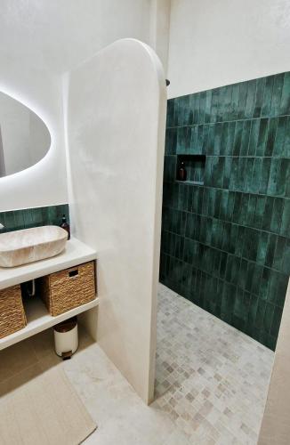 a bathroom with a sink and a green tiled wall at Sweet Apartment Aveiro Station in Aveiro