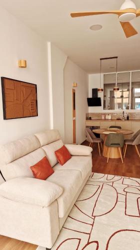 a living room with a white couch and a table at Sweet Apartment Aveiro Station in Aveiro