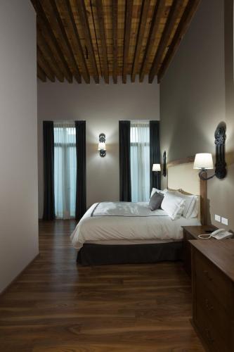 a bedroom with a large bed and two windows at Historico Central Hotel in Mexico City