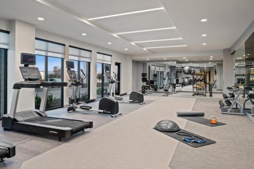 a gym with treadmills and exercise equipment and windows at Courtyard by Marriott Woodland in Woodland
