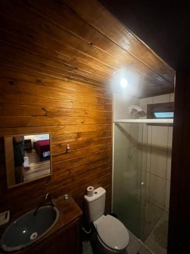 a bathroom with a toilet and a sink and a mirror at Hotel Rota do Corvo Branco in Grão Pará