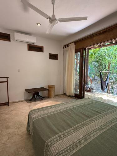 a bedroom with a bed and a ceiling fan at La baxada mazunte in Mazunte