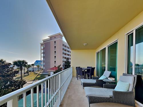 a balcony with chairs and tables and a view of the ocean at The Indies #209 in Fort Morgan