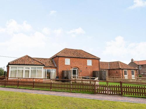 a brick house with a wooden fence at The Saddlery - Uk36123 in Horsington