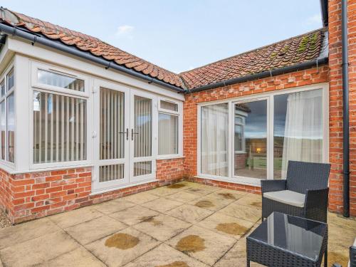 a patio with sliding glass doors on a brick house at The Saddlery - Uk36123 in Horsington
