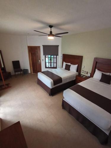 a hotel room with two beds and a ceiling fan at Hotel RINCON RESORT TEQUILA in Tequila