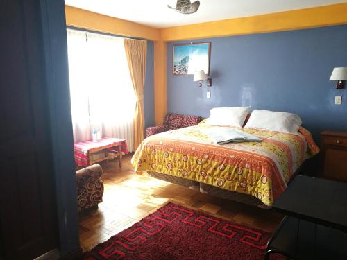 a bedroom with a bed and a chair and a window at Hotel Utama in Copacabana