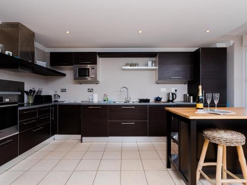 a kitchen with black cabinets and a wooden table at 16 Marinus in Cowes