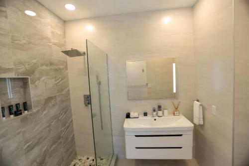 a white bathroom with a sink and a shower at 232C South Finger in Jolly Harbour
