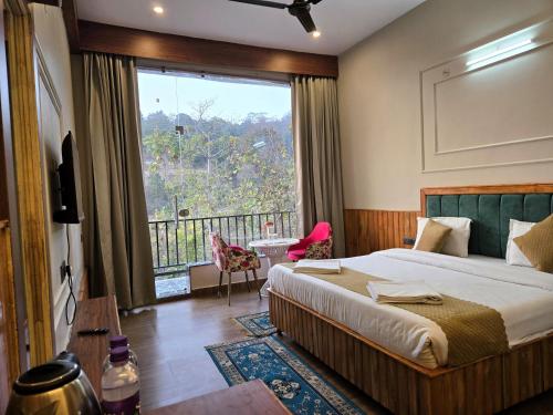 a bedroom with a bed and a large window at Corbett Mid Forest House - 1 Min Walk from Dabka River in Rāmnagar