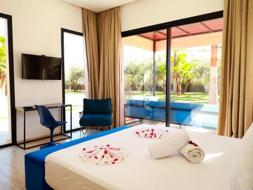 a hotel room with a bed and a large window at Villa des iris Domaines NAJMA in Marrakesh