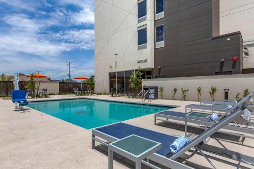 a swimming pool with lounge chairs and a building at Vīb Hotel by Best Western Phoenix - Tempe in Tempe