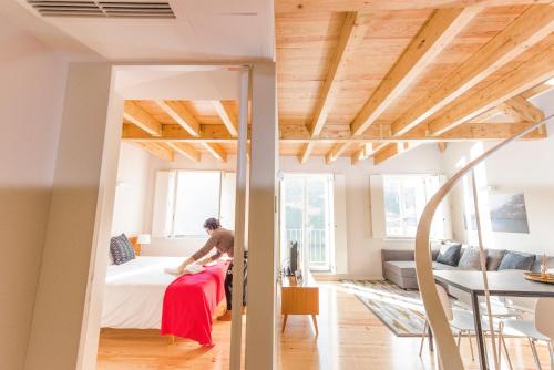 a man sitting on a bed in a room at Oporto Trendy River in Porto