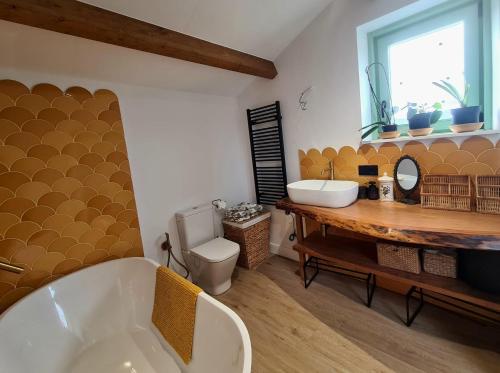 a bathroom with a tub and a toilet and a sink at El Sueño, Parrita in Barres