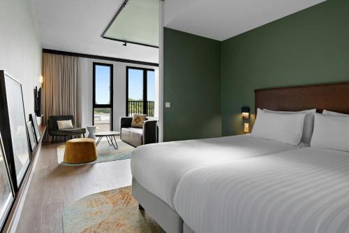 a bedroom with a bed and a living room at Residence Inn by Marriott Amsterdam Schiphol Airport in Badhoevedorp