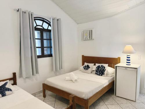 a bedroom with two beds and a window at Peixe Crew Rua das Pedras in Búzios
