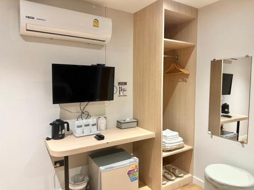 a room with a tv and a toilet in a room at V1 boutique hotel in Kanchanaburi City