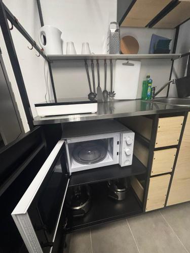 a microwave on a shelf in a kitchen at Monteur Boardinghouse WorkHomes Zuffenhausen in Stuttgart