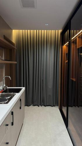 a kitchen with a sink and a large window at ديار الاسترخاء للشقق المخدومة اقتصادي in Najran