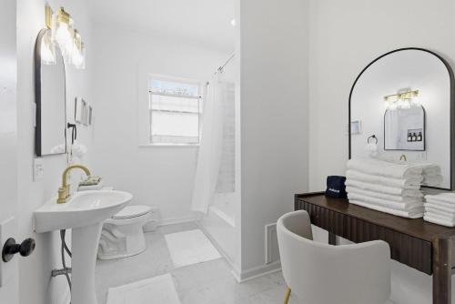 a white bathroom with a sink and a mirror at The Lake Charles Charmer in Lake Charles