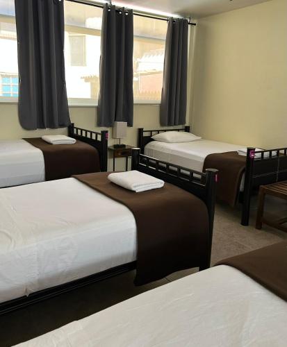 a room with three beds and a window at Hostal 109 Roma - Condesa in Mexico City