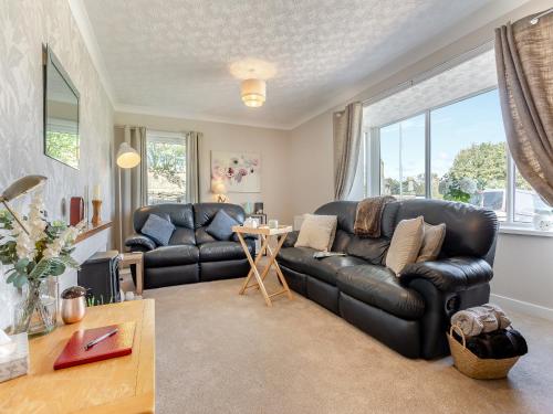 a living room with a black leather couch and a table at Tanera in Wick