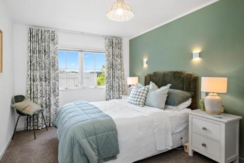 a bedroom with a large bed and a window at Kowhai Apartment-Ground Floor in Pukekohe East