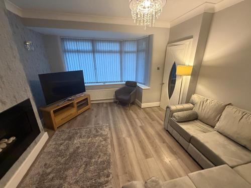 a living room with a couch and a flat screen tv at 2 Bed house - Brighouse close to McDonalds and B&M in Brighouse