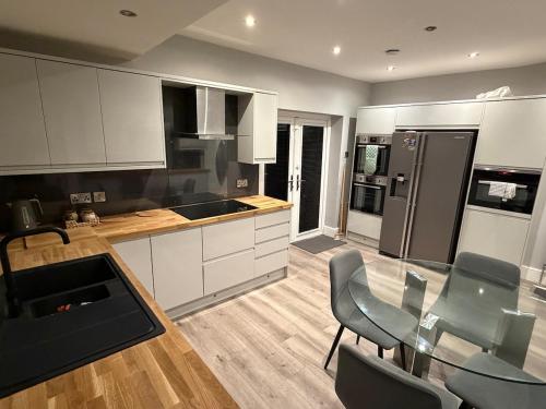 a kitchen with a glass table and chairs in a room at 2 Bed house - Brighouse close to McDonalds and B&M in Brighouse