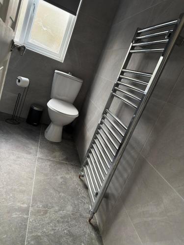a bathroom with a toilet and a metal ladder at 2 Bed house - Brighouse close to McDonalds and B&M in Brighouse