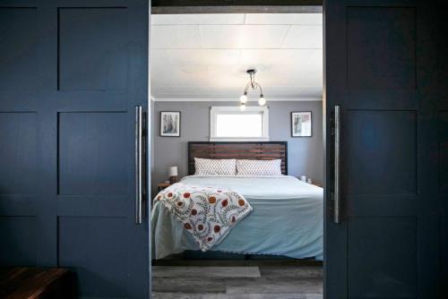 a bedroom with a bed with white sheets and a window at Rose Park Hideaway in Missoula