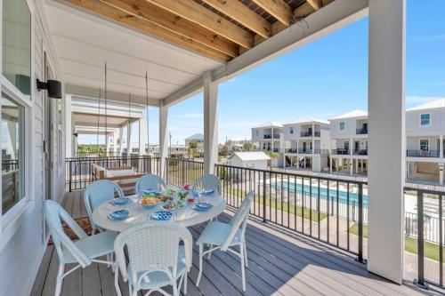 a patio with a table and chairs on a balcony at The Hangout House by The Madison Liv Collection in Gulf Shores
