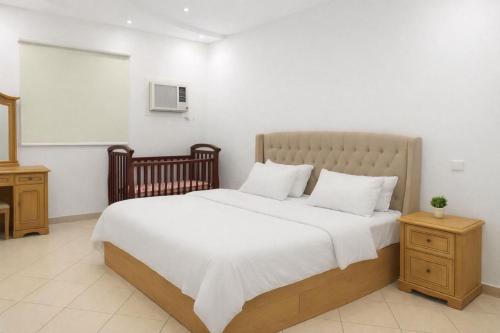 a bedroom with a large bed with white sheets at شقةكبيرة 4 غرف نوم وصالة بلكونه Large apartment with 4 bedrooms, a living room and a balcony in Taif