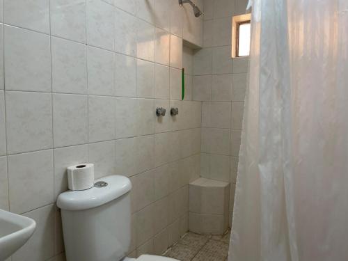 a white bathroom with a toilet and a shower at Casa 5 Centrica Super ubicada 3 camas queen in Hermosillo